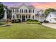 Traditional two-story home with a manicured lawn, mature landscaping, and a two-car garage at 113 Sycamore Ridge Ln, Holly Springs, NC 27540
