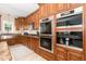 Modern kitchen features built-in double ovens, custom cabinetry, and granite counters at 113 Sycamore Ridge Ln, Holly Springs, NC 27540
