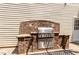 Outdoor kitchen featuring a stainless steel grill and brick surround on a stone patio at 113 Sycamore Ridge Ln, Holly Springs, NC 27540