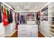 Well-organized walk-in closet with ample storage space and a decorative chandelier at 113 Sycamore Ridge Ln, Holly Springs, NC 27540