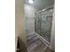 New bathroom with a glass-enclosed shower, rock floor, and white marble-look tile at 1209 Waterford Green Dr, Apex, NC 27502