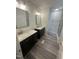 Bathroom featuring double sink vanities with dark cabinets and a glass-enclosed shower at 1209 Waterford Green Dr, Apex, NC 27502