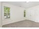 Neutral bedroom with carpeted floors and ample natural light from two windows at 1209 Waterford Green Dr, Apex, NC 27502