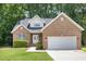 Charming brick home with a two-car garage, manicured lawn and mature trees at 1209 Waterford Green Dr, Apex, NC 27502