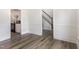 Hallway featuring laminate floors, white walls, stairs and glimpses of the kitchen at 1209 Waterford Green Dr, Apex, NC 27502