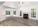 Spacious living room with a fireplace, large windows, and laminate flooring at 1209 Waterford Green Dr, Apex, NC 27502
