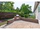 Outdoor patio featuring brick pavers and a built-in grill, surrounded by lush landscaping, perfect for entertaining at 128 Arvind Oaks Cir, Cary, NC 27519