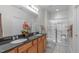 Well lit bathroom featuring double sinks with dark counters and a glass shower with a built-in seat at 128 Arvind Oaks Cir, Cary, NC 27519
