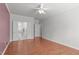 Spacious primary bedroom with hardwood floors, a ceiling fan, and a private ensuite bathroom with double doors at 128 Arvind Oaks Cir, Cary, NC 27519