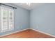 Bedroom with hardwood flooring, a large window, neutral paint, and base molding at 128 Arvind Oaks Cir, Cary, NC 27519