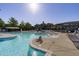Beautiful community pool with lounge chairs, a water slide, and a charming recreation building in the background at 128 Arvind Oaks Cir, Cary, NC 27519