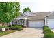 Charming home with a two-car garage, stone accents, well-manicured landscaping, and a welcoming covered front porch at 128 Arvind Oaks Cir, Cary, NC 27519