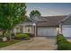 Charming single-story home boasting a manicured lawn, a two-car garage, and beautiful stone and siding accents at 128 Arvind Oaks Cir, Cary, NC 27519