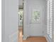 Bright hallway featuring hardwood flooring and white trim leading to the home's front door and an adjacent living space at 128 Arvind Oaks Cir, Cary, NC 27519