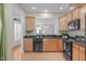 Traditional kitchen featuring wooden cabinets, dark countertops, stainless steel appliances, and hardwood flooring at 128 Arvind Oaks Cir, Cary, NC 27519
