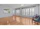 Living room with hardwood flooring, large windows, and access to other living spaces at 128 Arvind Oaks Cir, Cary, NC 27519