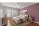 Cozy bedroom with plush carpeting, a king bed, bedside tables, and a bright window dressed with white shutters at 128 Arvind Oaks Cir, Cary, NC 27519