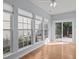 Sunroom with hardwood flooring, many windows, and a sliding glass door to the outside at 128 Arvind Oaks Cir, Cary, NC 27519
