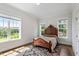 Bright bedroom features hardwood floors, an ornate wooden bed, and a scenic view from the large windows at 1342 Briar Chapel Pkwy, Chapel Hill, NC 27516