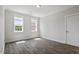 Well-lit bedroom featuring hardwood floors, white walls, two windows, and a closet with a solid door at 1342 Briar Chapel Pkwy, Chapel Hill, NC 27516