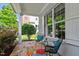 Cozy front porch featuring flagstone flooring, comfortable seating, and picturesque views of the landscaped yard and shrubbery at 1342 Briar Chapel Pkwy, Chapel Hill, NC 27516