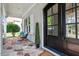 Inviting front porch with stone flooring, stylish seating, and a charming entrance with a black framed windowed door at 1342 Briar Chapel Pkwy, Chapel Hill, NC 27516