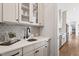Elegant kitchen with wet bar, designer backsplash, and stainless steel sink at 1342 Briar Chapel Pkwy, Chapel Hill, NC 27516