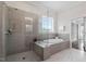 Luxurious main bathroom with a glass shower, soaking tub, and gray tiled surround at 1342 Briar Chapel Pkwy, Chapel Hill, NC 27516