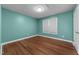 Bright bedroom with hardwood floors, fresh paint, and natural light from a window at 1383 Deercroft Ct, Graham, NC 27253
