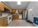 Functional kitchen boasts stainless appliances, oak cabinets, and tile floors at 1383 Deercroft Ct, Graham, NC 27253