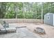 Spacious backyard featuring a stone fire pit, privacy fence, lounging chairs, and storage shed at 142 College Ave Ave, Durham, NC 27713