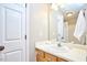 Simple vanity bathroom with white ceramic sink and door to a toilet at 142 College Ave Ave, Durham, NC 27713