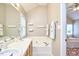 Bright bathroom with double sinks, soaking tub, and neutral tile at 142 College Ave Ave, Durham, NC 27713
