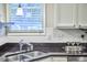 Kitchen with stainless steel sink and black countertops with bright light from large window at 142 College Ave Ave, Durham, NC 27713