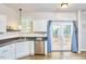 Bright kitchen with stainless steel appliances, white cabinetry, and a view to the deck at 142 College Ave Ave, Durham, NC 27713