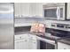 Kitchen featuring white cabinets, stainless steel appliances, and dark countertops at 142 College Ave Ave, Durham, NC 27713