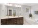Bathroom with double sinks, vanity, tub, standing shower, and bright lighting at 143 Thornbury St, Clayton, NC 27527