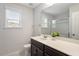 Bright bathroom features a large mirror, brown vanity, and window for natural light at 143 Thornbury St, Clayton, NC 27527