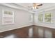 Bright bedroom featuring a tray ceiling, ceiling fan, and hardwood flooring at 143 Thornbury St, Clayton, NC 27527
