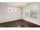 Bright dining room with wainscoting, dark hardwood floors and a chandelier at 143 Thornbury St, Clayton, NC 27527
