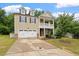 Charming two-story home boasts a well-manicured lawn, attached garage, and inviting covered porch at 143 Thornbury St, Clayton, NC 27527