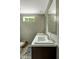 Bathroom featuring a marble-look countertop, framed mirror, and window to wooded exterior at 150 Will Woods Way, Franklinton, NC 27525