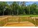 An eye-level view of a light wood deck with railing overlooking a wooded lot on a sunny day at 150 Will Woods Way, Franklinton, NC 27525
