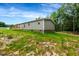 Side of the home with gray siding, brick foundation, wood deck, and green trees at 150 Will Woods Way, Franklinton, NC 27525