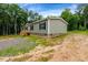 View of a home featuring gray siding, brick foundation, and lush green surroundings at 150 Will Woods Way, Franklinton, NC 27525