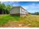 Home exterior featuring gray siding, brick foundation and a wood porch at 150 Will Woods Way, Franklinton, NC 27525