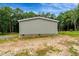 Rear view of home with gray siding, brick foundation, surrounded by green landscape and trees at 150 Will Woods Way, Franklinton, NC 27525