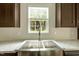 A kitchen with a stainless steel sink, marble counter tops, and wood cabinets at 150 Will Woods Way, Franklinton, NC 27525