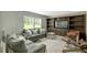 Carpeted living room with a gray sofa, built-in shelving, and windows at 150 Will Woods Way, Franklinton, NC 27525