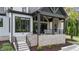 Covered porch with stone fireplace and seating area offers a relaxing space, enhanced by the professionally landscaped yard at 15517 Possum Track Rd, Raleigh, NC 27614